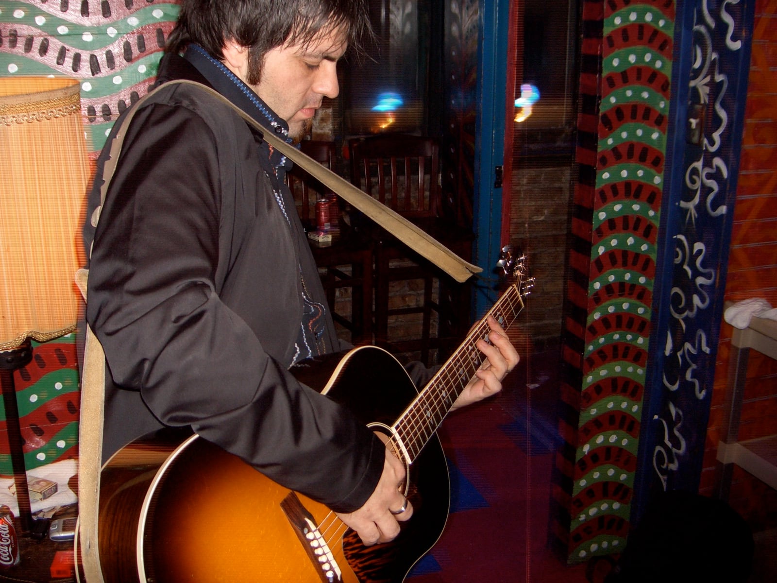 Nathan Dale playing a sunburst acoustic guitar in 2006