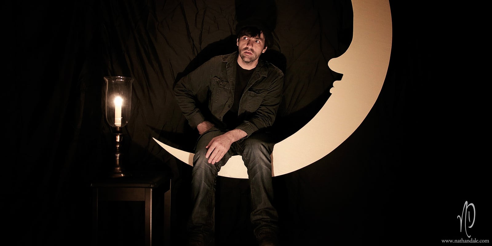 Nathan Dale seated beside a lamp and crescent moon for the 2011 Major Key's Parade promotional photographs