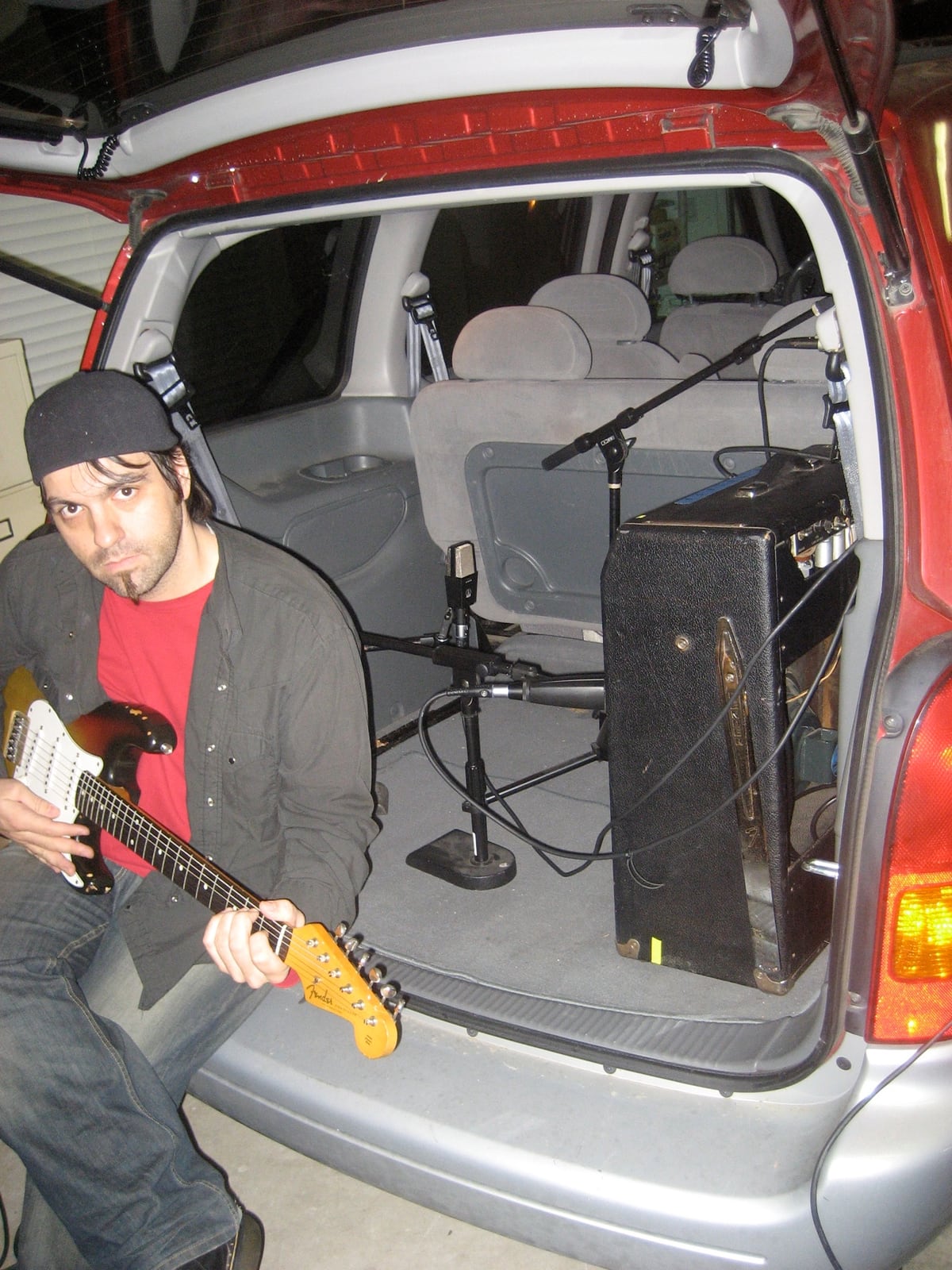 Nathan Dale recording guitar through an amplifier and microphones arranged inside a Dodge Caravan during an early experiment with Bruce Spencer in 2008